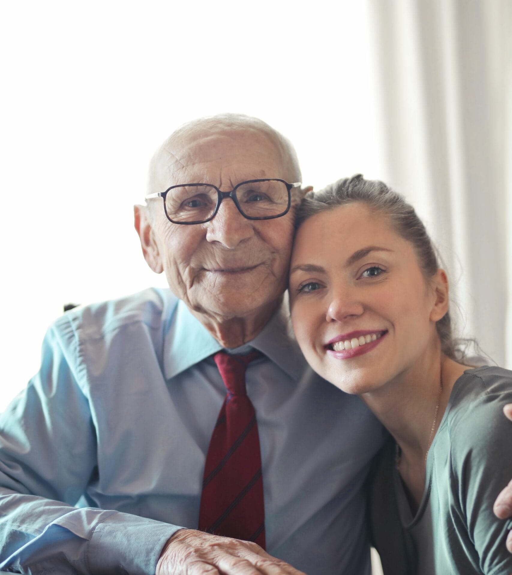 Elderly Man & Caregiver Embraced Facing Camera and Smiling